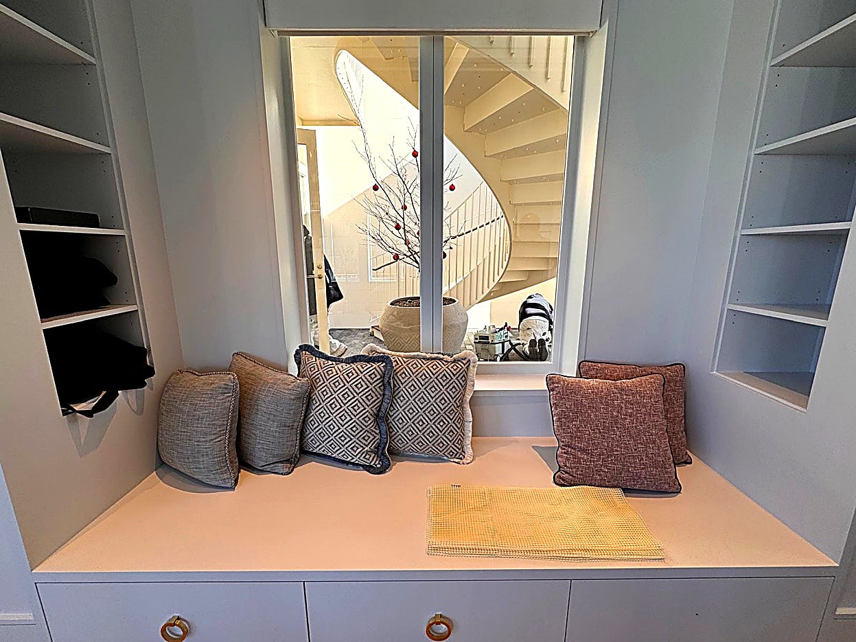 Perry D. Smith &mdash; Window seat with decorative pillows and spiral staircase view